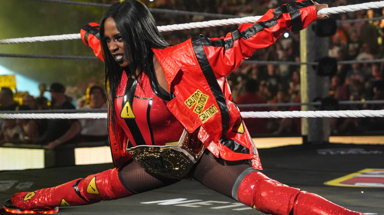 Naomi leans against the bottom and middle ropes during her entrance as the WWE Women's World Champion.