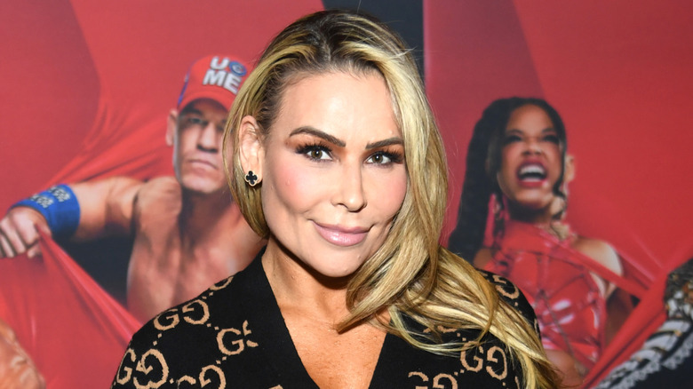 Natalya standing in front of a WWE poster