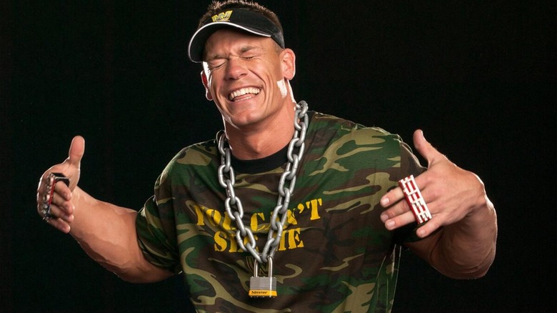 John Cena laughing during outtakes for a photoshoot while showing off his spinner WWE US Championship.