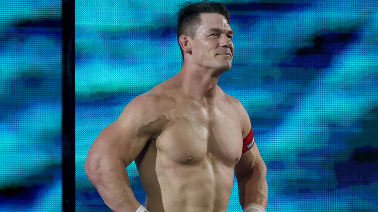 John Cena is smiling and putting his hands on his hips