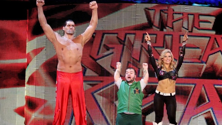 The Great Khali, Natalya, and Hornswaggle pose together on the stage before a match on an episode of 