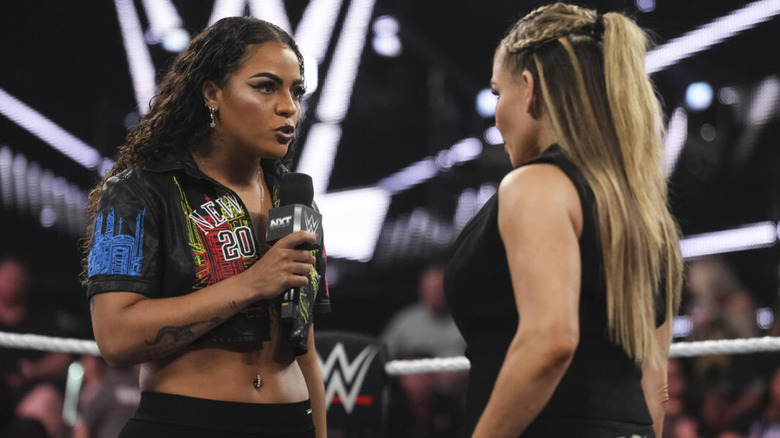 Jaida Parker holding a microphone while Natalya stares her on