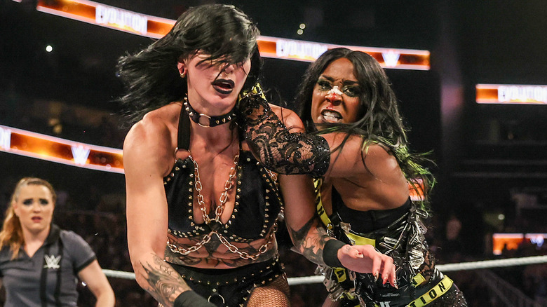 Naomi throwing Rhea Ripley in the ring