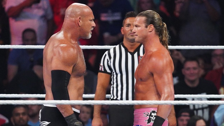 Dolph Ziggler and Goldberg facing off in the ring with a ref near them