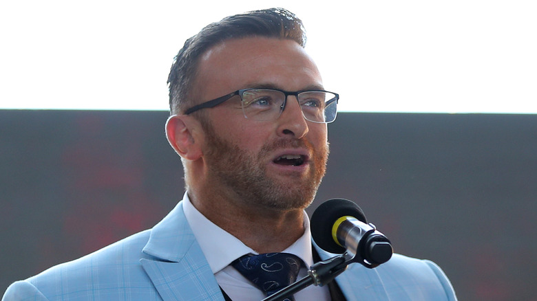 Nick Aldis speaks while wearing glasses