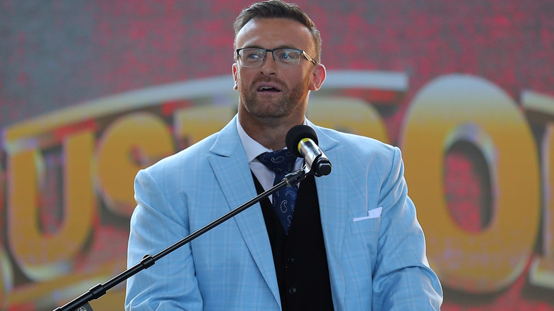 Nick Aldis wearing a blue suit