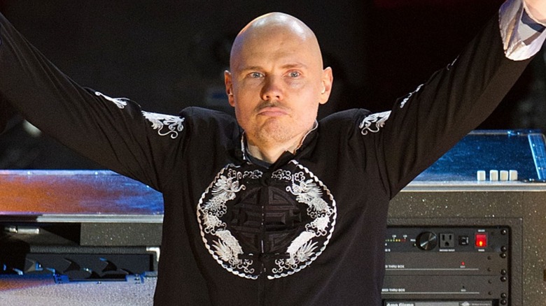 Billy Corgan with his arms raised