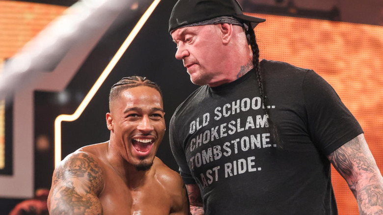 Carmelo Hayes smiling with The Undertaker