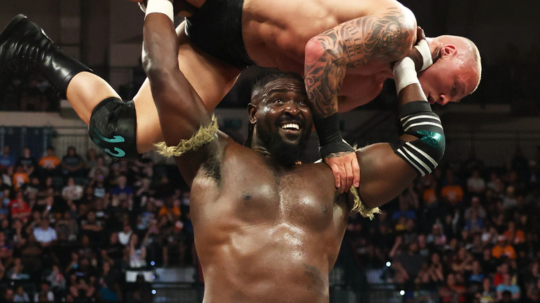 Oba Femi holding Myles Borne in the air