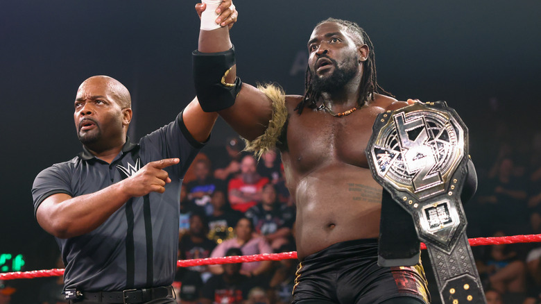 A WWE referee holds up 