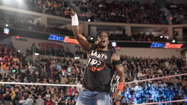 R-Truth holding a mic in the air