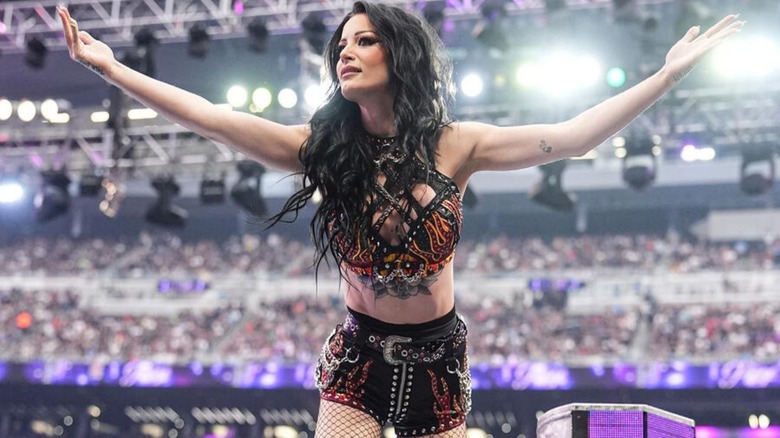 Paige poses and gestures toward the crowd after her surprise return at WWE WrestleMania 42.