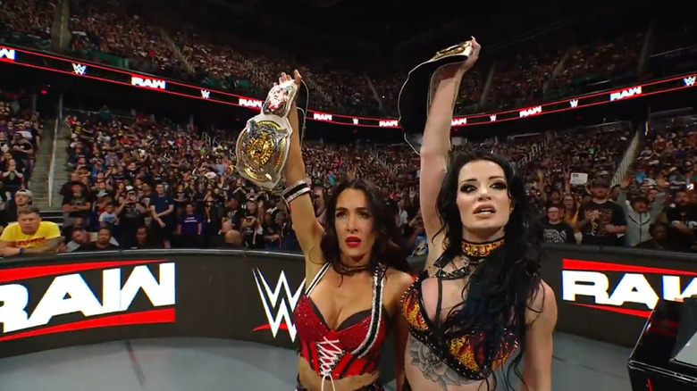 Brie Bella and Paige hold the Women's Tag titles aloft