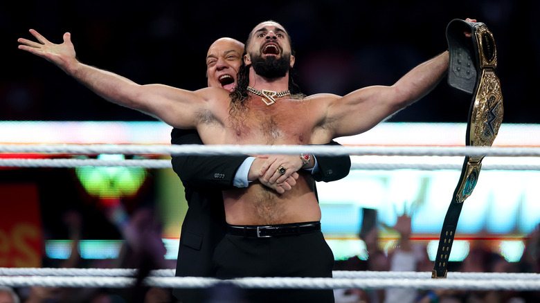 Seth Rollins celebrates with his manager Paul Heyman after winning the WWE World Heavyweight Championship after cashing in his Money in the Bank contract to take on CM Punk during the WWE 2025 SummerSlam at MetLife Stadium on August 02, 2025 in East Rutherford, New Jersey.