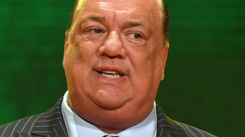 Heyman in front of a green background at a press conference