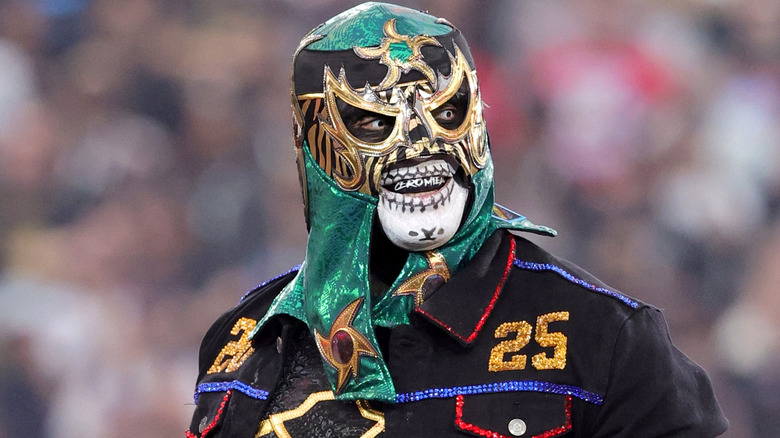 Penta wearing a green and black mask