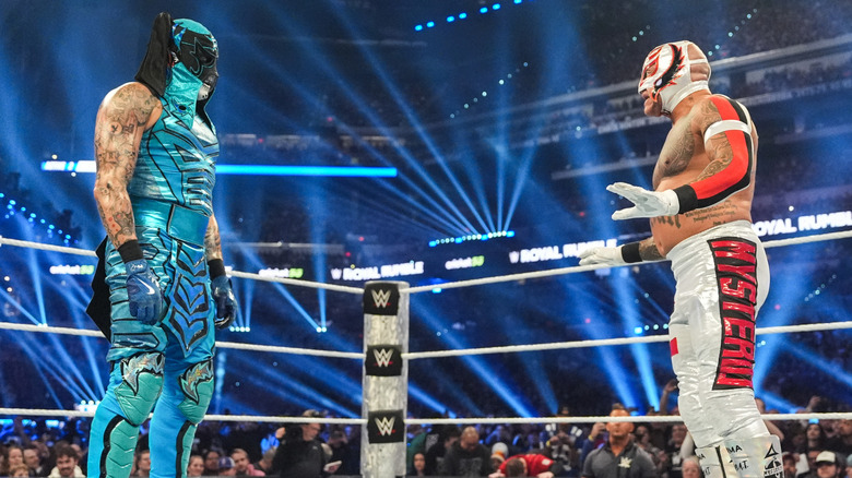 Penta and Rey Mysterio staring off