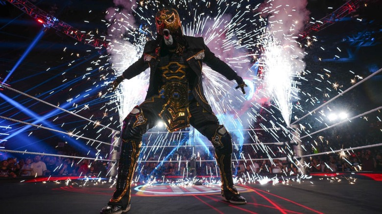Penta poses in the ring, his pyro going off behind him, during his entrance before a match on 