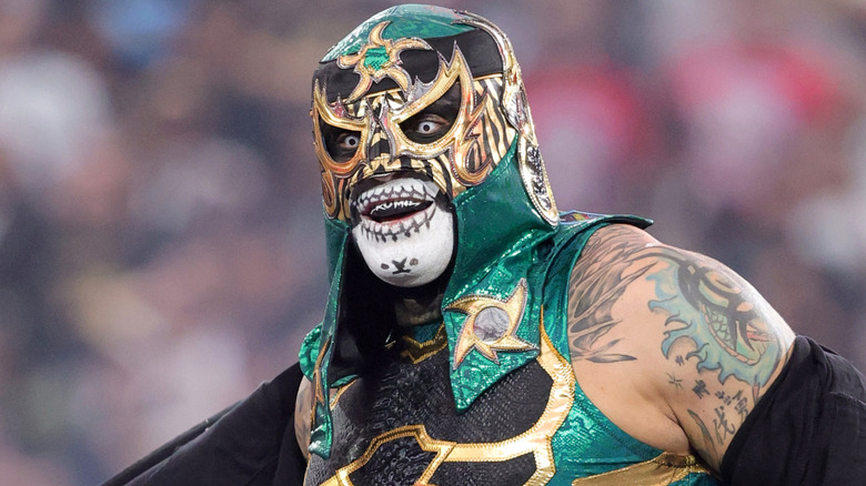 Penta wearing a green and black mask