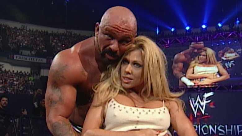 Perry Saturn embracing Terri Runnels from behind during a television segment.