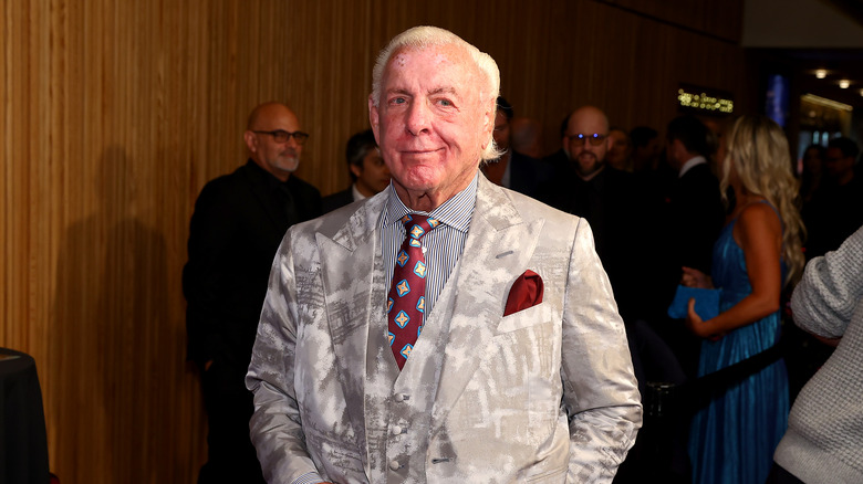 Ric Flair smirks in a suit