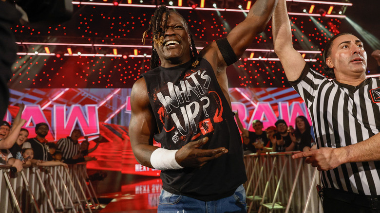 R-Truth getting his arm raised by a referee outside the ring