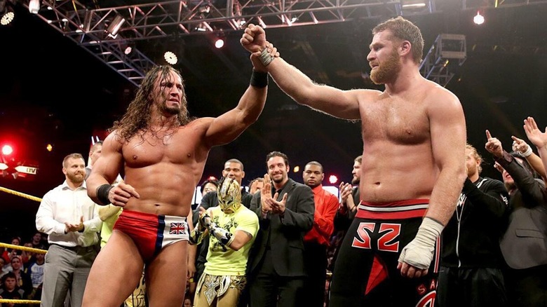 Adrian Neville raises Sami Zayn's arm in the ring while the "NXT" roster applauds at NXT Takeover: R Evolution