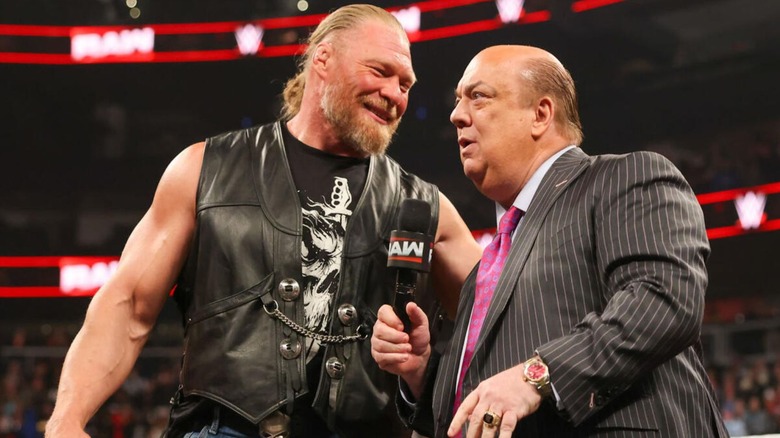 Brock Lesnar leans in to Paul Heyman during a promo segment on an episode of 