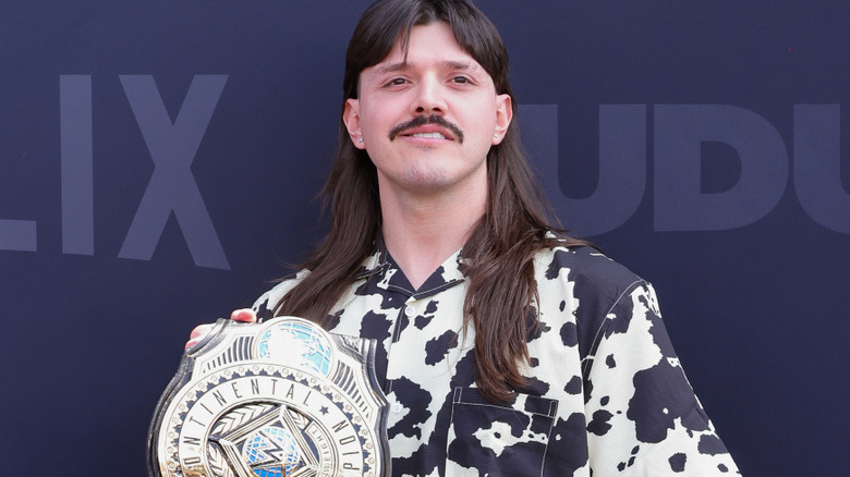 Dominik Mysterio holding his WWE Intercontinental Championship