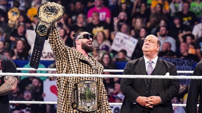 World Heavyweight Champion Seth Rollins holds up the belt while wearing the Crown Jewel Championship around his waist on an episode of 