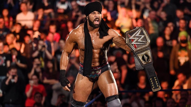 Raj Dhesi (formerly known as WWE star Jinder Mahal) poses with the former WWE Championship in the ring before his scheduled match
