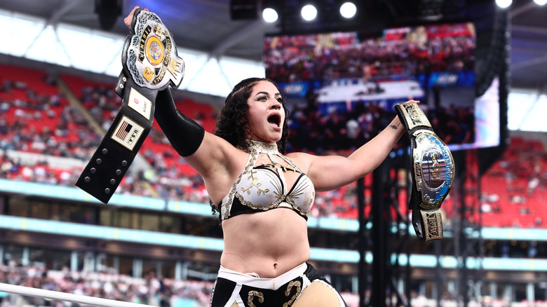 Persephone holds up the CMLL World Women's title and the TBS Championship after winning the latter from Maya World at AEW All In London 2026.