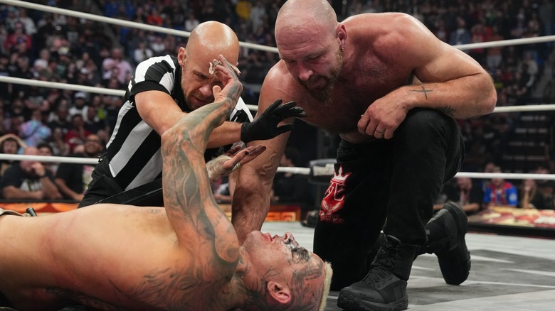 Jon Moxley kneeling over Darby Allin to get him to quit during their match at AEW WrestleDream, 2025.