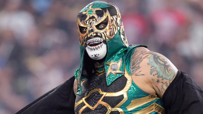 Penta wearing a green and black mask