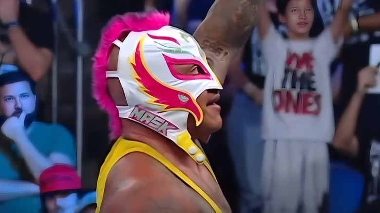 Rey Mysterio raises an arm