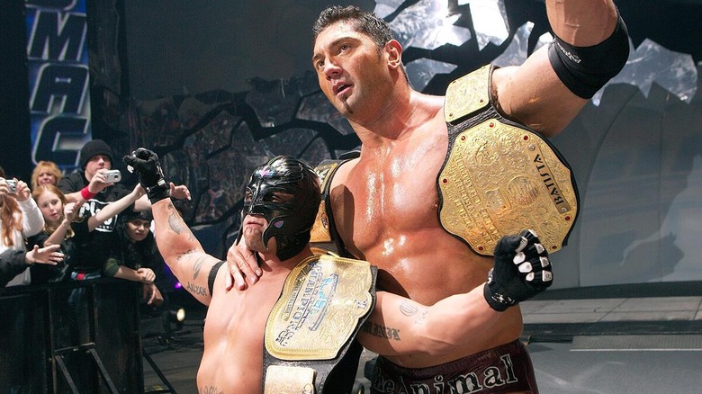 Rey Mysterio and Batista celebrating together after a match on 