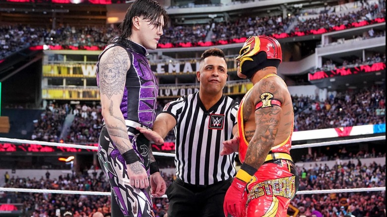 Dominik and Rey Mysterio are separated by a referee