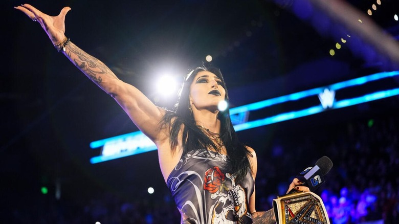 Rhea Ripley poses for the crowd, WWE Women's Championship in hand, before cutting a promo on 