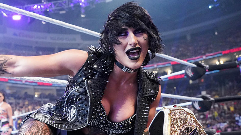 Rhea Ripley holding the WWE Women's World Championship on the ring apron