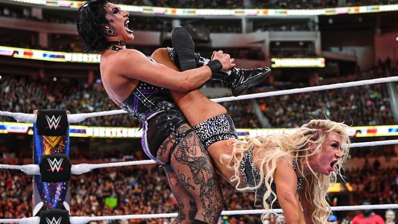 Rhea Ripley puts Charlotte Flair in a submission hold in the middle of the ring during their match at WrestleMania 39.