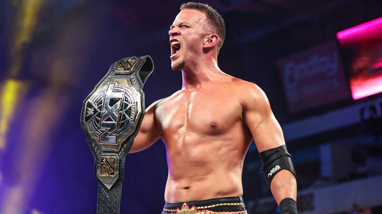 Ricky Saints posing with the NXT Championship.