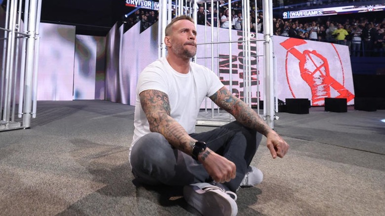 CM Punk sits on the stage following his return at the end of WWE Survivor Series: War Games in his hometown of Chicago.