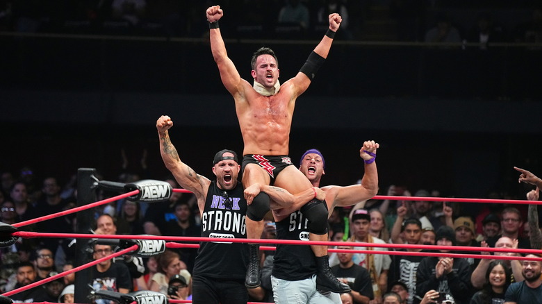 Roderick Strong poses on The Kingdom's shoulders