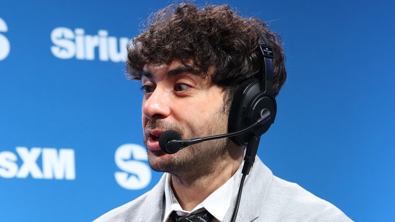 Tony Khan speaking in front of a blue SiriusXM background