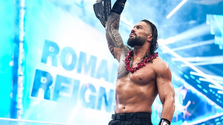 Roman Reigns lifts up the World Heavyweight Championship and poses in the ring ahead of his title match against Seth Rollins at WWE SummerSlam 2026.