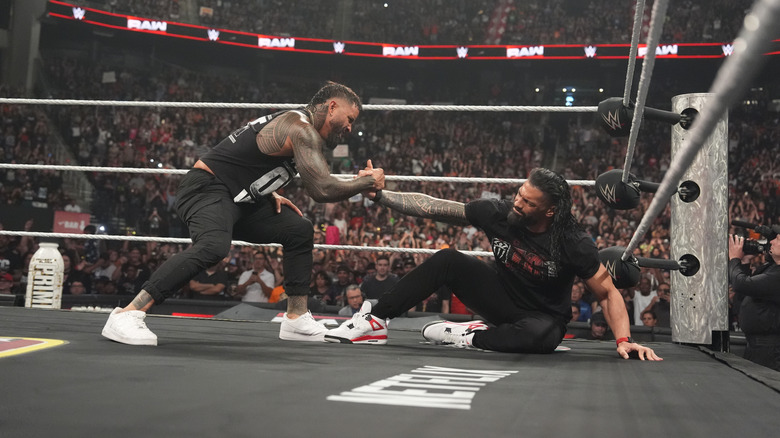 Jey Uso helps Roman Reigns up