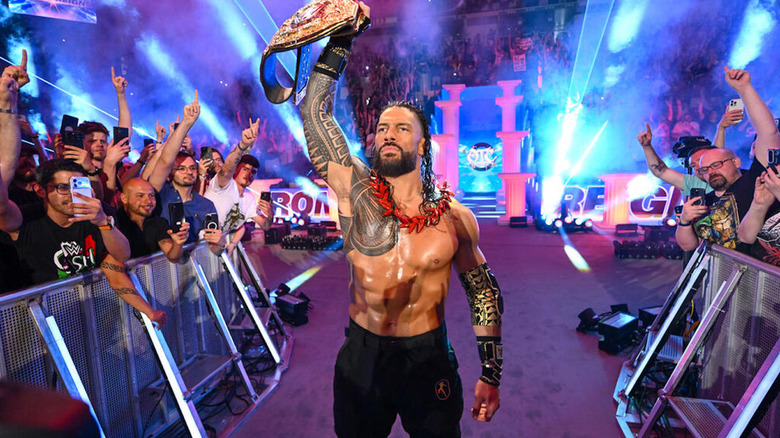 Roman Reigns holding the WWE World Heavyweight Championship in the air