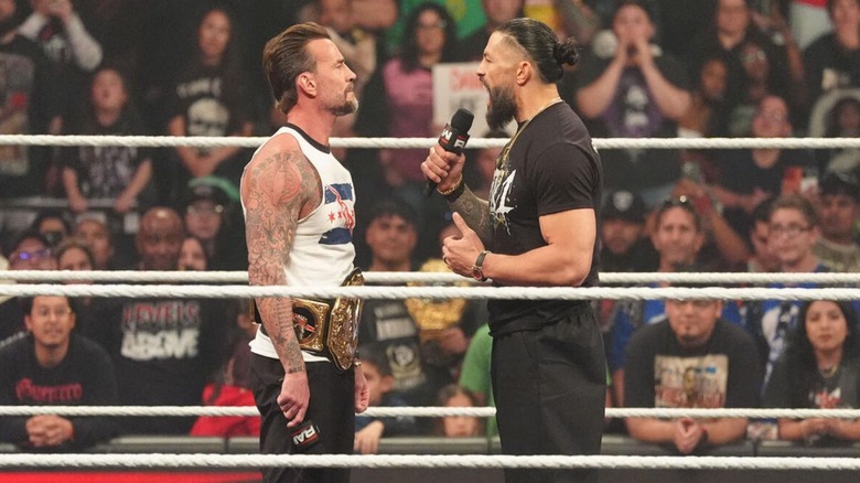 Roman Reigns cuts a promo on CM Punk during their main event segment in the ring on an episode of 