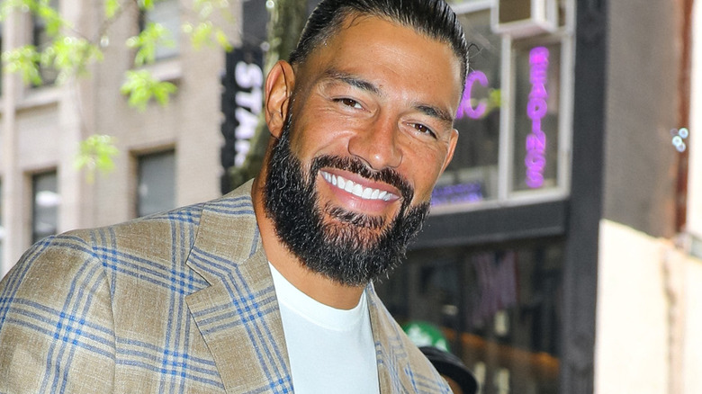 WWE star Roman Reigns smiling outside