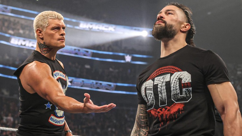 Cody Rhodes reaching out to shake hands with Roman Reigns to establish a shaky alliance ahead of Bad Blood 2024.